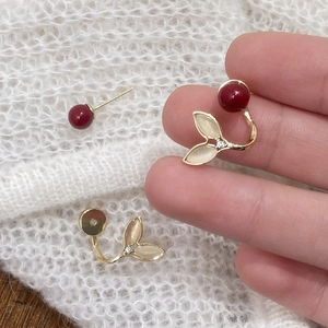 Elegant gold fishtail earrings with red pearls and white cat-eye stone leaves