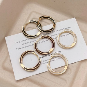 Three pairs of elegant gold-plated hoop earrings with black, red, and beige enamel inlay