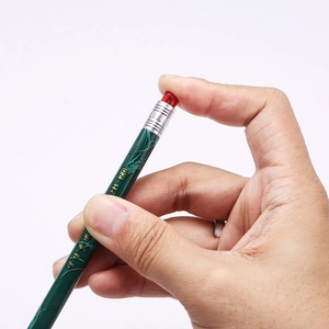 Macro detail of 2B exam pencil featuring green bamboo design and gold lettering