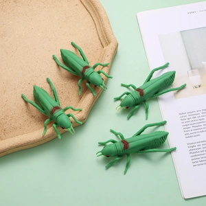 Detail shot of four realistic green grasshopper pens on a desk with soft lighting