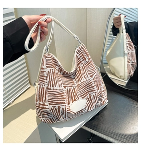 Détail du sac hobo en tissu jacquard marron et bandoulière en cuir blanc
