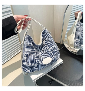 Détail du sac cabas jacquard bleu et blanc avec des lanières en similicuir blanc