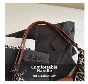 Detailed close-up of leopard print tote bag with brown faux leather handle and zipper