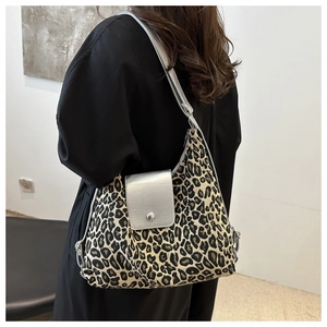 Détail du sac léopard avec rabat argenté métallisé porté par un mannequin