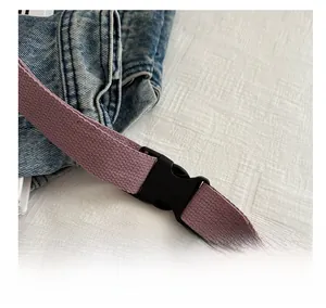 Détail de la boucle robuste et de la sangle en tissu d'un sac de poitrine en nylon violet