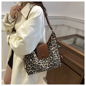Détail d'un sac cabas léopard avec rabat en cuir marron et boucle ronde élégante