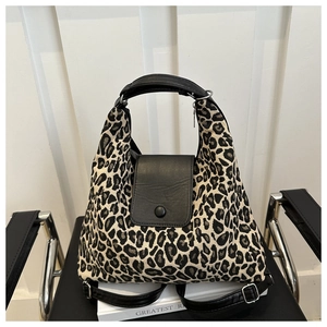 Gros plan du sac fourre-tout léopard sur chaise noire montrant texture et fermoir