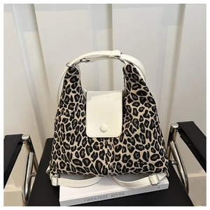 Détail du sac cabas léopard avec finitions en cuir blanc et boucles métalliques argentées