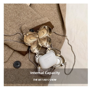 Vue macro d'un sac papillon doré montrant la capacité pour des AirPods Pro