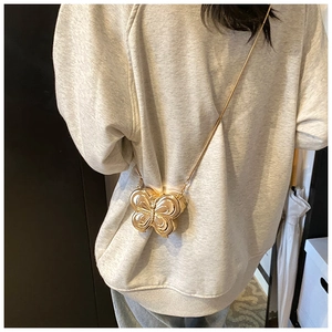 Mini sac papillon doré porté en bandoulière avec une fine bandoulière en chaîne