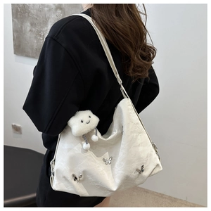 Detail of white tote bag with silver butterfly charms and plush cloud keychain