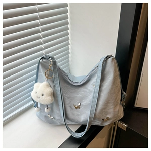 Détail du sac hobo plissé bleu clair avec breloques papillon et pendentif nuage