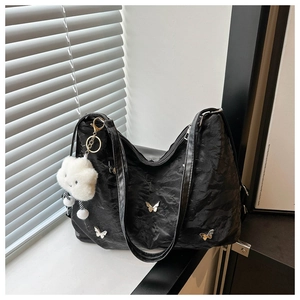 Détail du sac cabas plissé noir avec papillons argentés et pendentif nuage en peluche