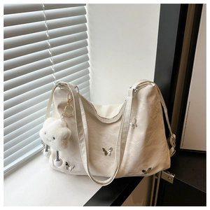 Détail du sac cabas plissé blanc crème avec breloques papillons et pendentif nuage doux