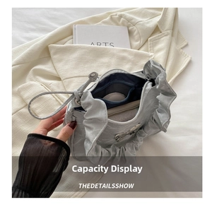 Internal view of silver pleated shoulder bag showing spacious storage for daily items