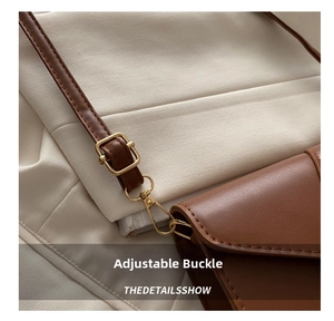 Detail shot of the brown leather shoulder bag featuring an adjustable gold buckle