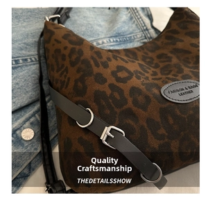 Detail der Leoparden-Einkaufstasche mit schwarzem Lederriemen und silbernen Metallteilen