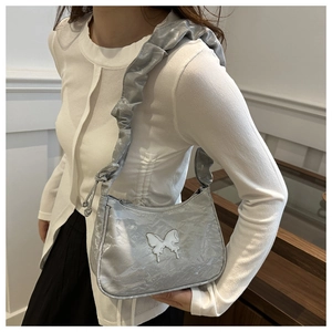 Close-up of metallic silver pleated cloud bag featuring a liquid metal butterfly buckle