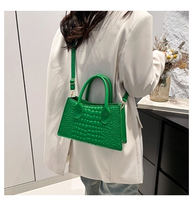 Detailansicht der leuchtend grünen Kroko-Handtasche mit eleganten goldenen Beschlägen