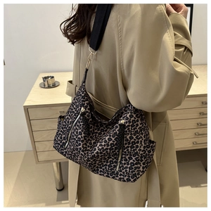 Side view of leopard print tote bag with black wide strap on trench coat outfit