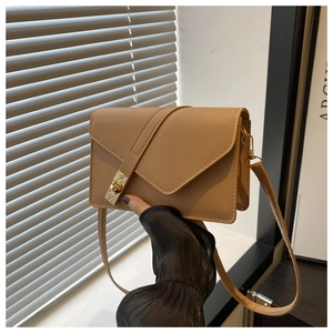 Close-up of khaki geometric flap shoulder bag with gold rectangular swivel metal lock