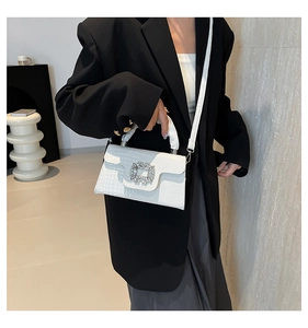 Detail of white crocodile pattern handbag with luxury square crystal buckle on flap