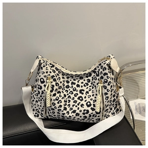 Detail of leopard print hobo bag showing white fabric strap and gold hardware accents