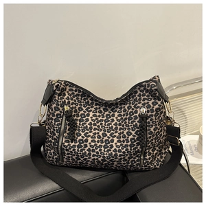 Detail of leopard print canvas tote bag featuring functional front zipper pockets