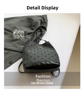 Detail view of grey canvas drawstring bucket bag with black polka dots and metal bow