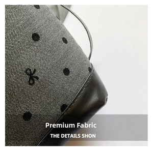 Detail showing herringbone fabric with polka dots and black leather patchwork on the tote bag