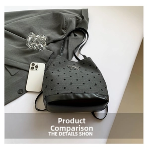 Detailed view of grey polka dot tote bag with silver bow accent and leather bottom