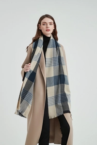 Close-up of blue and beige plaid thick winter scarf with soft fringed edge detail
