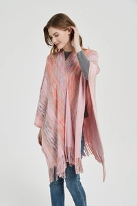 Close-up of multi-color gradient knit poncho with long fringe trim on a female model
