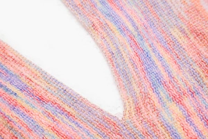 Detail of space-dyed knit shawl showing colorful V-shaped neckline and woven texture