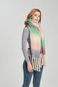 Detail eines weichen Strickschals mit Farbverlauf und dicken cremefarbenen Fransen am Saum