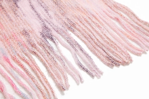 Macro detail of knit shawl fringe featuring pink and purple gradient yarn textures
