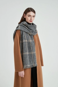 Detail of classic houndstooth scarf with soft fringe trim and cozy cashmere texture