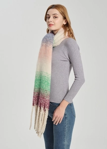 Nahaufnahme eines weichen Strickschals mit Farbverlauf und langen Fransenquasten