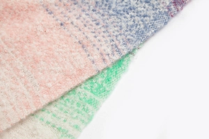 Detail eines weichen karierten Schals in Pastellrosa und Blau mit flauschiger Textur