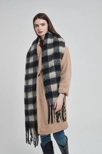 Détail d'une écharpe épaisse à carreaux avec franges et manteau d'hiver camel