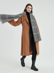 Detail of classic black and white houndstooth scarf styled with a camel winter wool coat