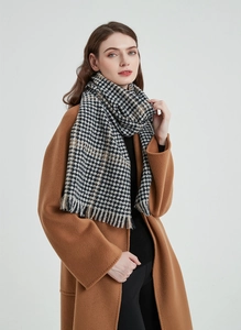 Detail shot of black and white houndstooth scarf texture with brown accents and tassels