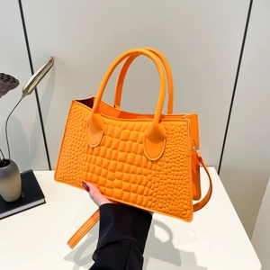Leuchtend orangefarbene Handtasche mit Krokodilprägung, Tragegriff und Schultergurt
