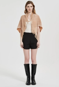 Detailed view of knitted striped shawl with tassel edges and soft woven texture