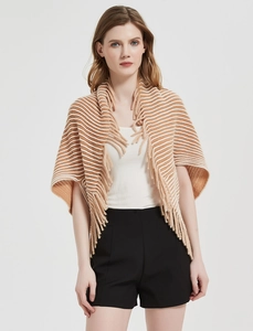 Close-up of knit stripes and decorative fringe on a camel and white women's shawl