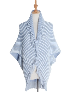 Close-up of blue and white striped knit poncho with soft fringed collar and plush texture