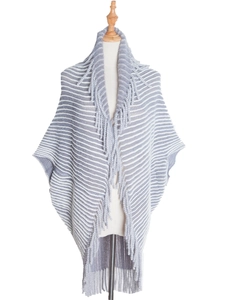 Detailed view of grey and white striped knit poncho featuring long tassel trim edges