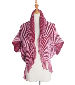 Detail of red and white striped knit shawl featuring long fringe edges on a mannequin
