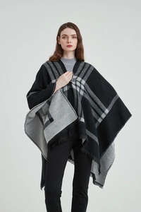 Détail d'un poncho à carreaux noir et gris avec texture cachemire et fermeture à boucle