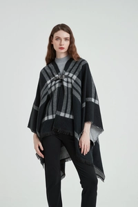 Détail d'un châle à carreaux noir et gris avec boucle en cuir et franges élégantes
